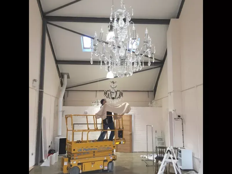 Feature chandelier being installed from a scissor lift in a Northamptonshire building