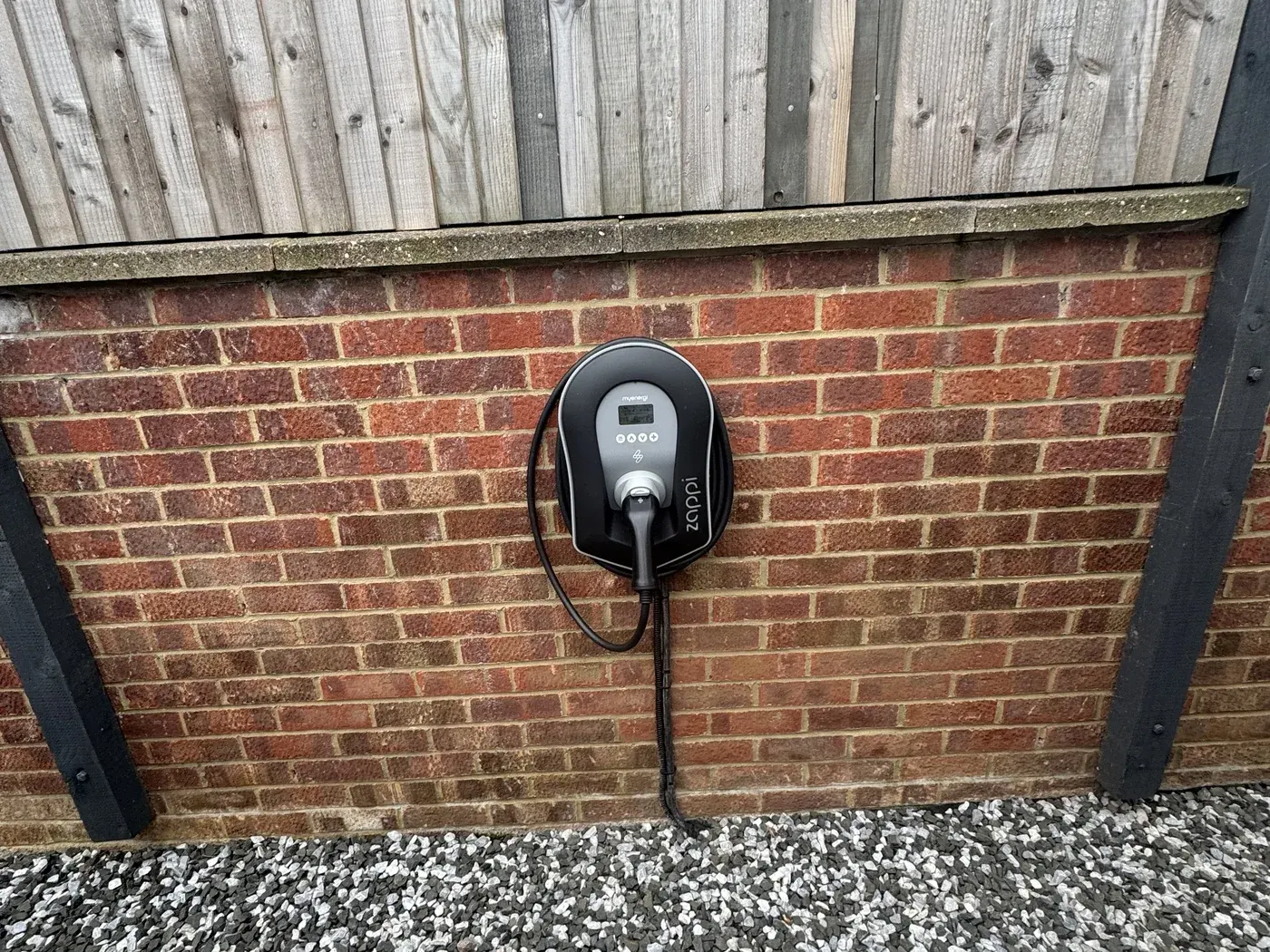 Home EV charge point installed on a house wall in a village near Wellingborough